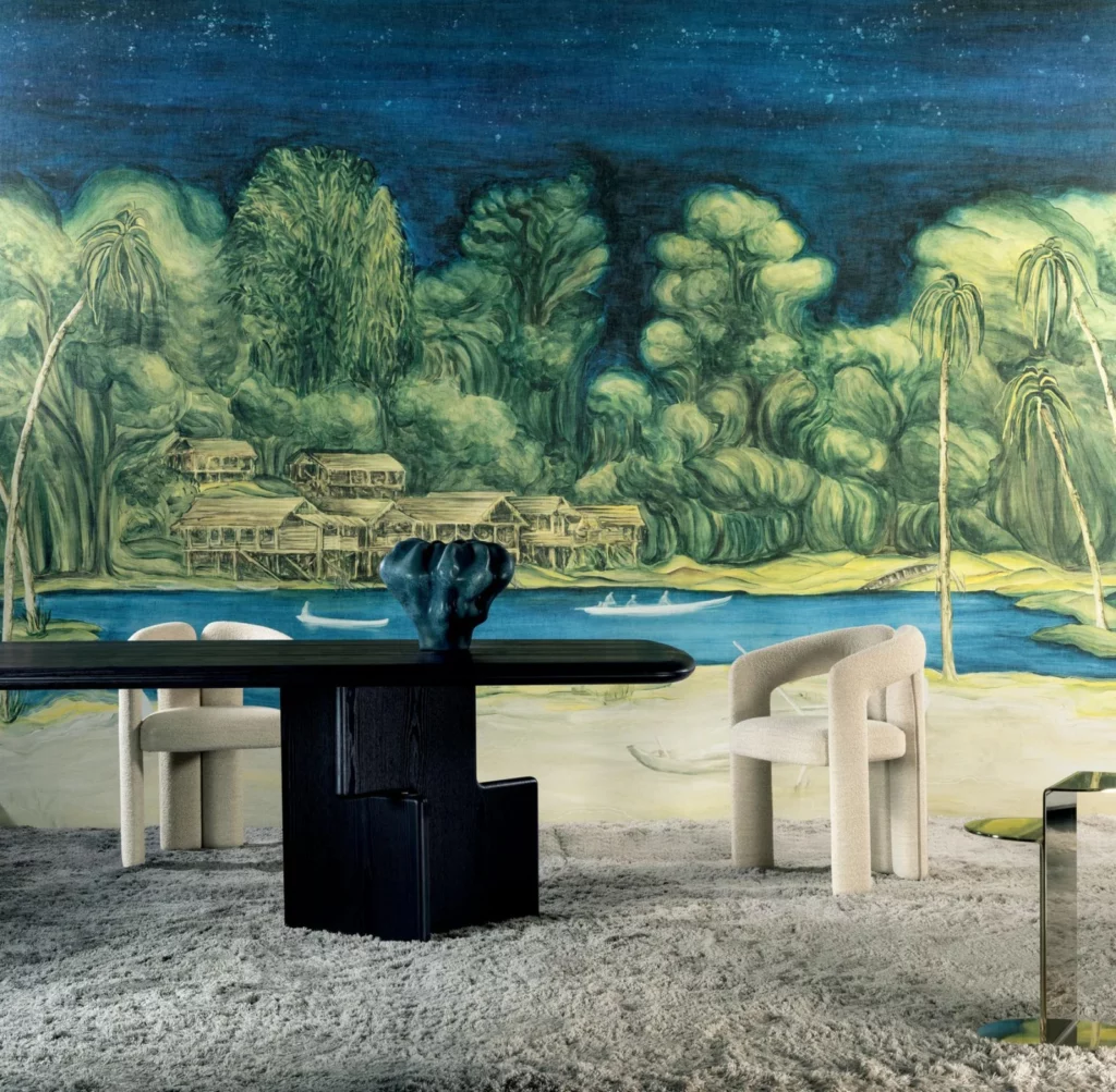 Arte Riva: grün-blaues Flussuferpanorama mit üppigen Bäumen hinter einem dunklen runden Tisch.