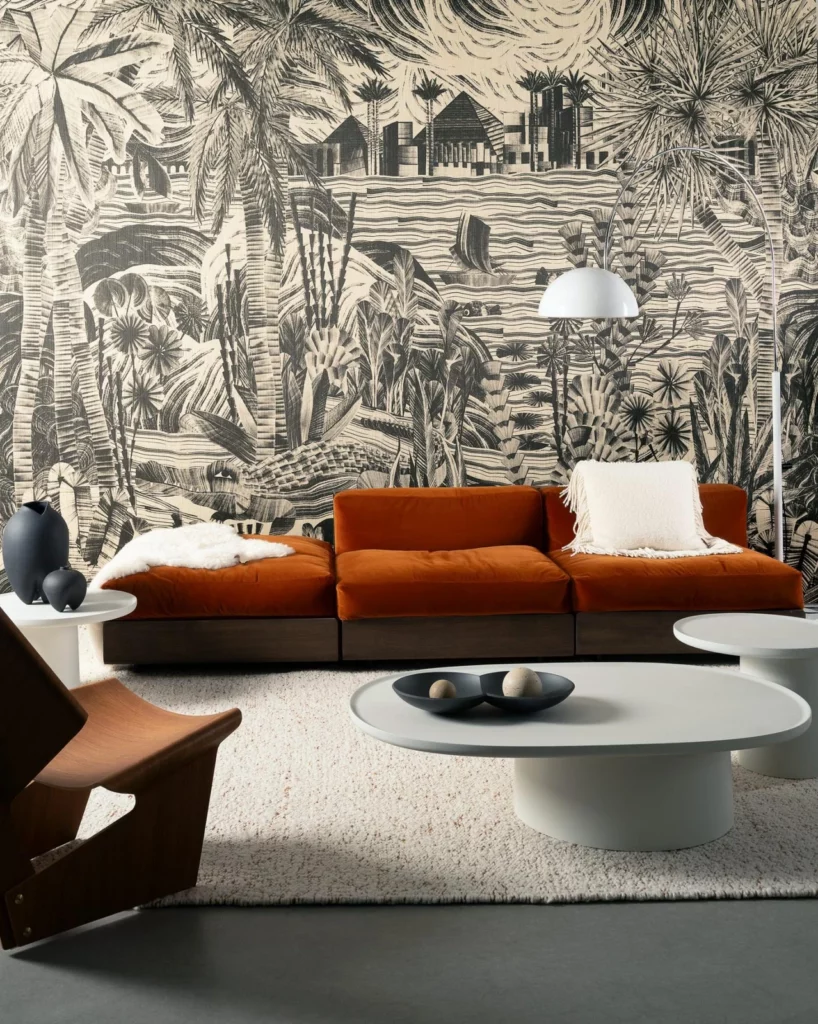 Arte Thebe: schwarz-weißes Landschaftspanorama mit Palmen und Gebäuden hinter einem rostfarbenen Sofa.