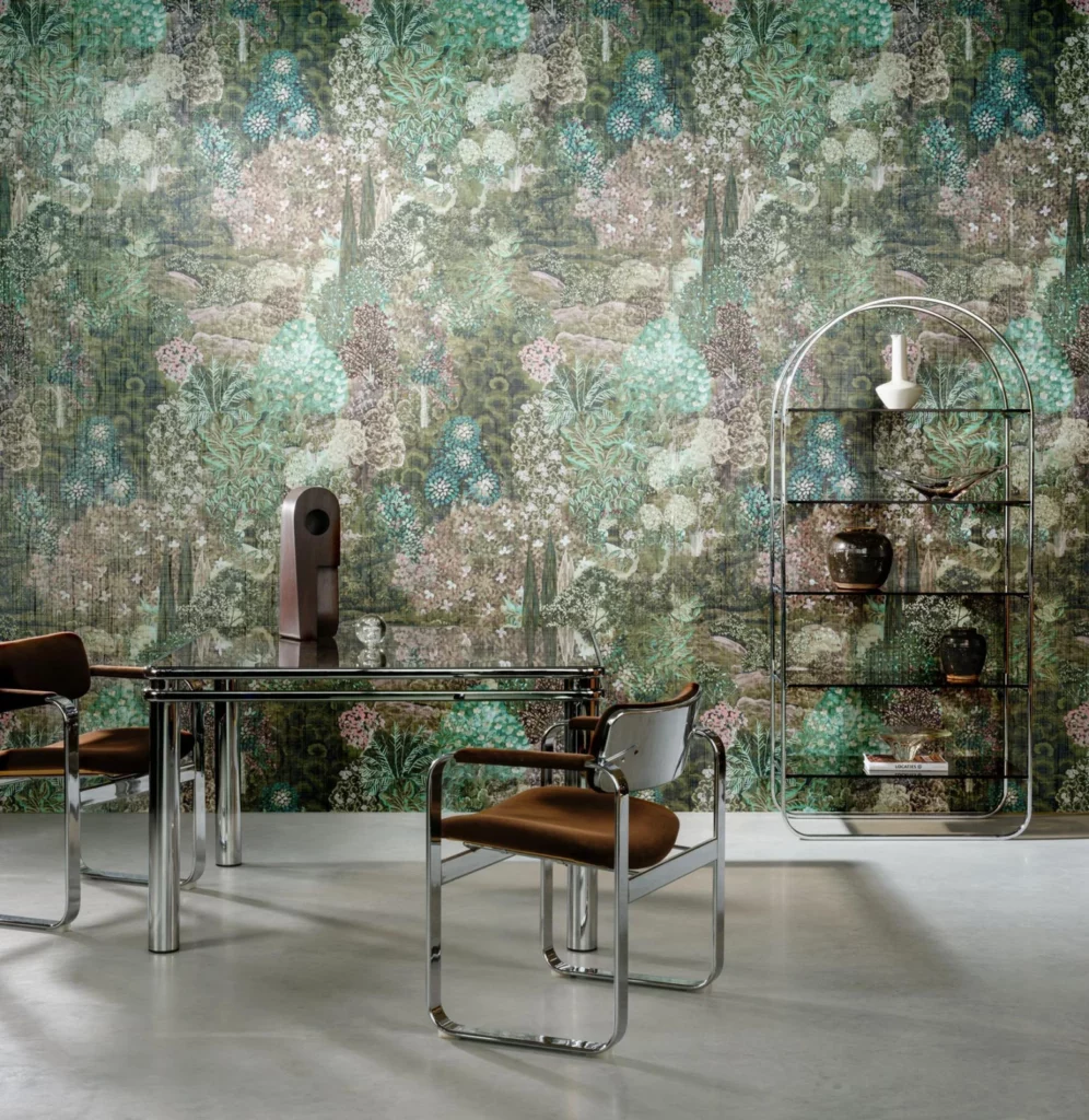 Arte Forêt des Muses: grün schimmerndes botanisches Wandmotiv hinter einem Glastisch und einem offenen Regal.
