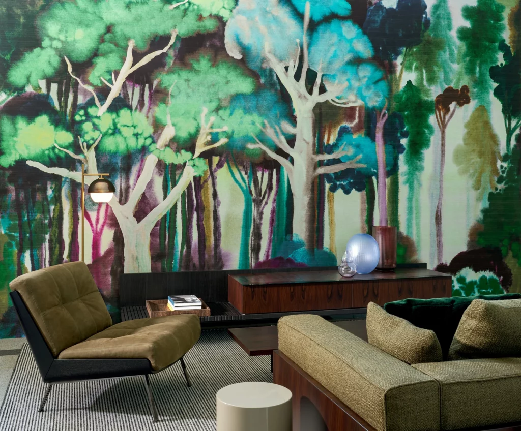 Arte Banyan: leuchtend grünes Waldpanorama hinter einer Sitzgruppe mit olivgrünen Sesseln.