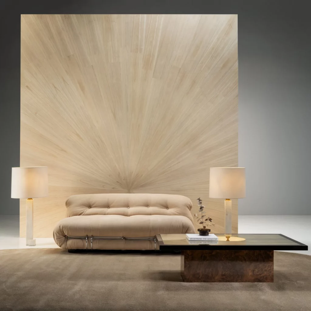 Arte Sunburst: strahlenförmiges Wandbild in hellen Holztönen hinter einem beigefarbenen Sofa.