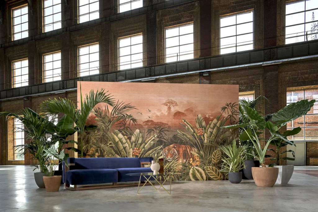 Arte Silk Road Garden: breites tropisches Landschaftspanorama hinter einer blauen Sitzbank in einer hohen Halle.