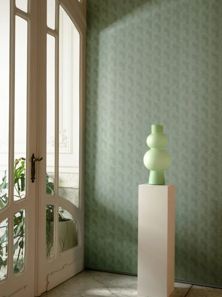 Arte Benoe: zurückhaltendes grünes Muster neben einer hellen Tür und einer Vase auf einem Sockel.