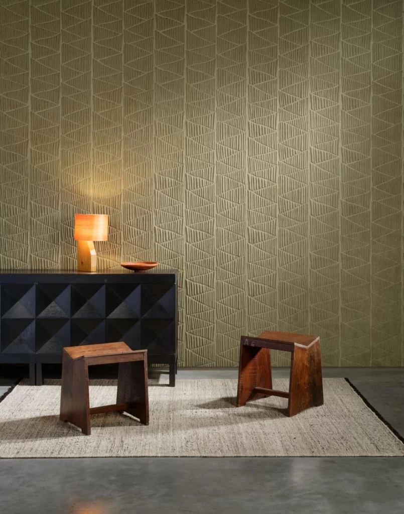 Arte Siwa: grünes Wandrelief mit feinen geometrischen Linien hinter einem dunklen Sideboard.