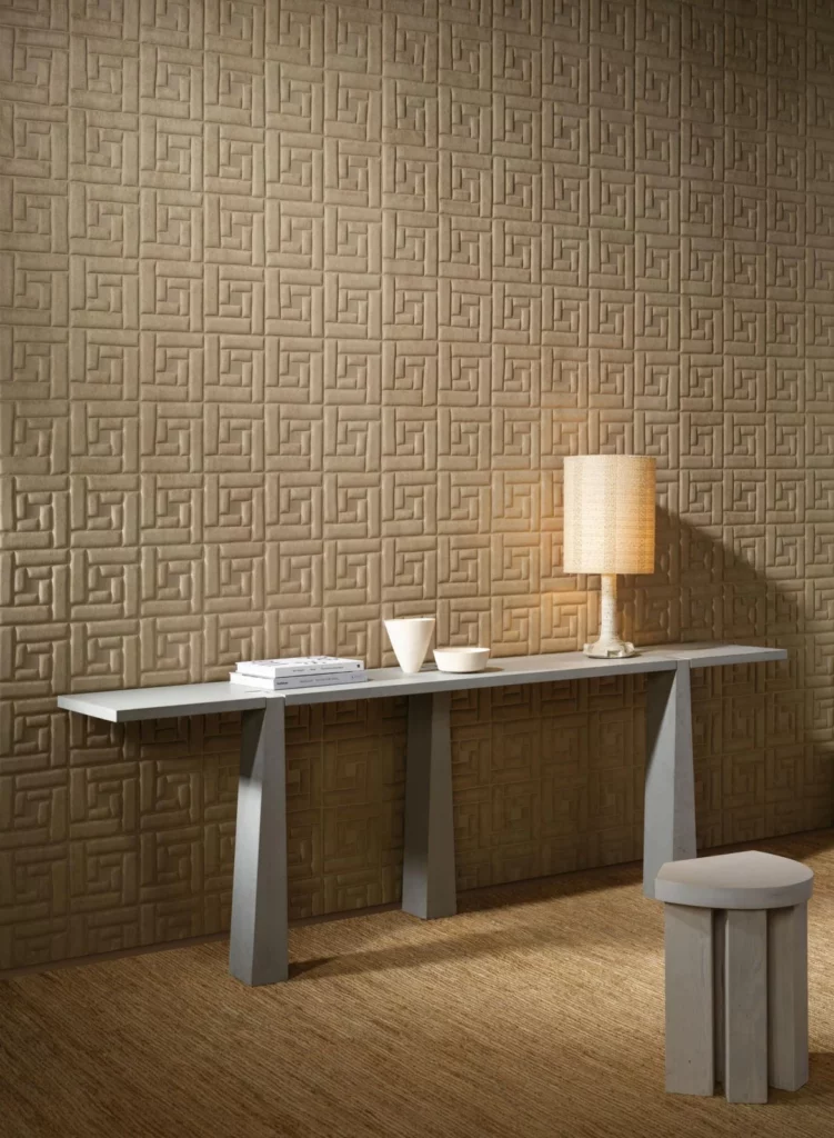 Arte Sakkara: beiges Wandrelief mit verschachtelten Linien hinter einem langen Tisch.