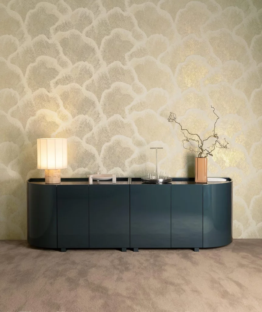 Arte Nefeli: hellgoldenes Wolkenmuster über einem dunkelgrünen Sideboard.