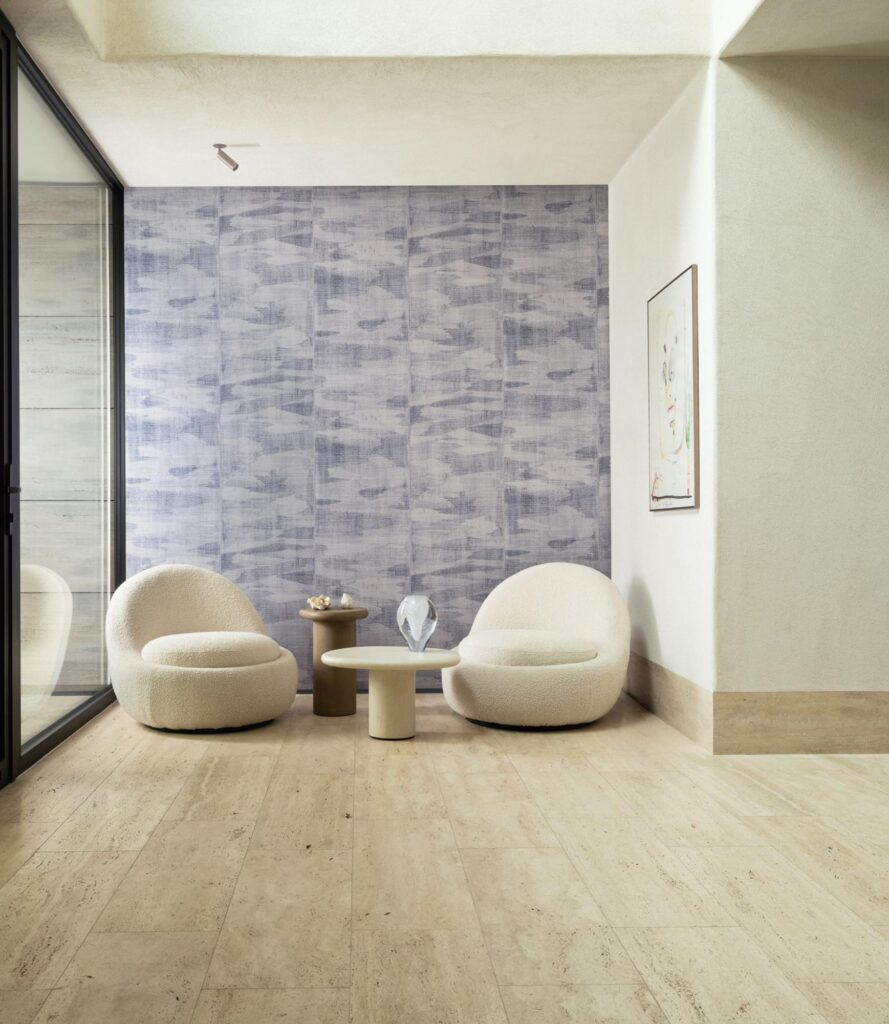 Arte Alluvio: blaugraue, wolkig strukturierte Wand hinter zwei hellen Sesseln neben einer Glasfront.