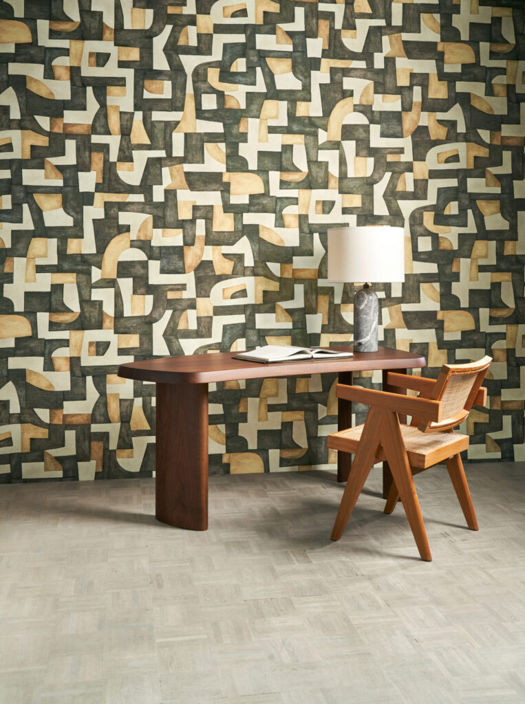 Arte Ecoline: geometrisches Wandmotiv in warmen Naturtönen hinter einer Essgruppe aus Holz.