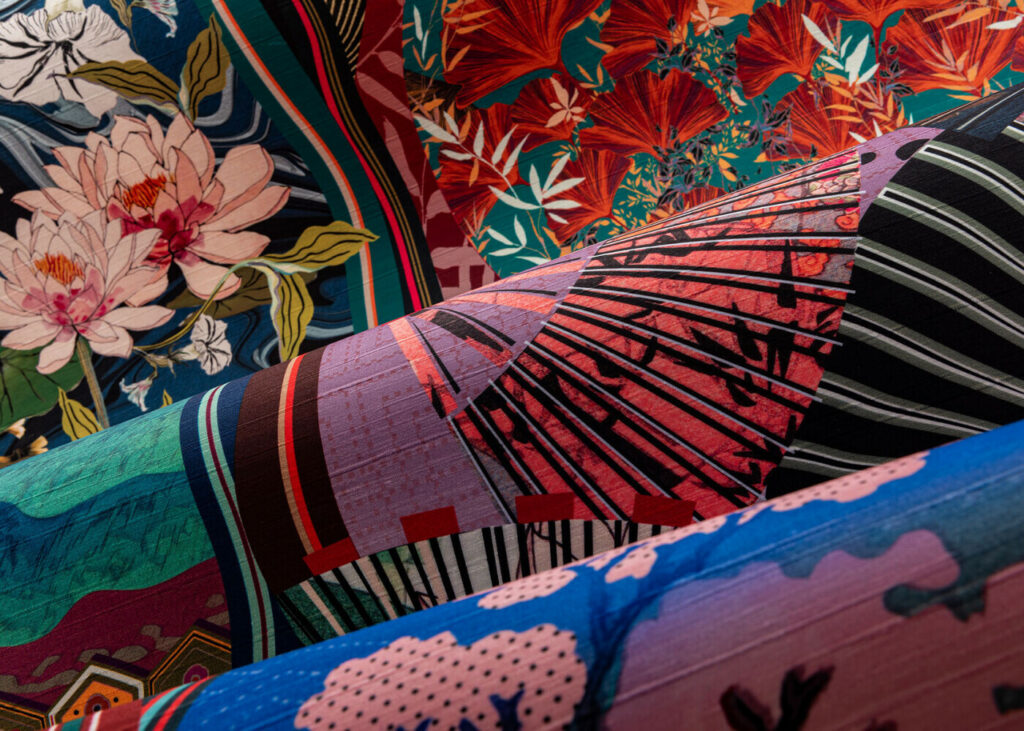 Arte Kimono: nahaufnahme des farbigen Motivs mit Fächern, Blüten und fernöstlichen Szenen.