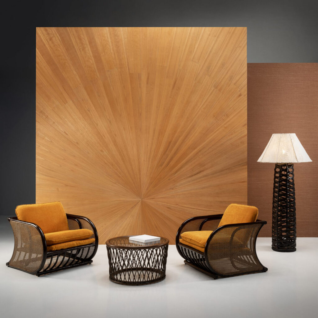 Arte Sunburst: fächerförmiges Wandmotiv in warmen Holztönen hinter zwei gelb gepolsterten Sesseln.
