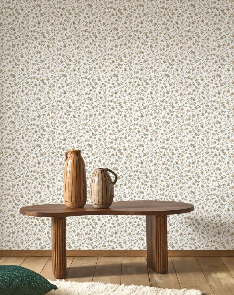 Klein gemusterte Blumentapete hinter einem Holztisch mit Keramikvasen aus der Kollektion Maison de famille.