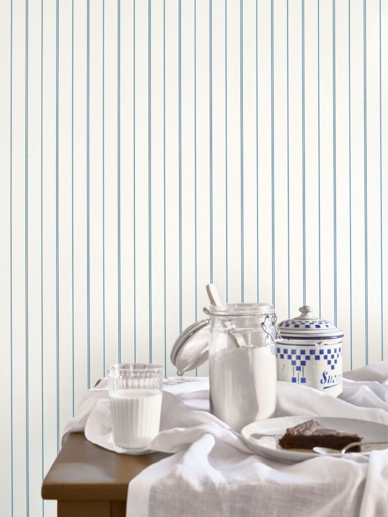 Helle Streifentapete hinter einem Tisch mit Karaffe und Geschirr aus der Kollektion Maison de famille.