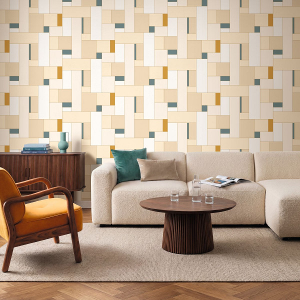 Geometrische Flächen in Creme-, Senf- und Naturtönen hinter einem hellen Sofa.
