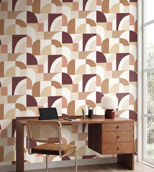 Großes geometrisches Rapportmuster in Beige und Bordeaux hinter einem Schreibtisch.