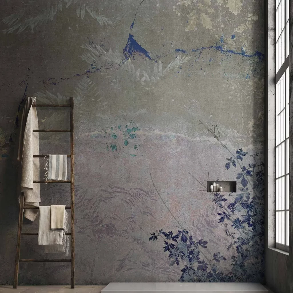 Jura von Tecnografica: patinierte graue Wandbildoptik mit blauen Vögeln und botanischen Formen.
