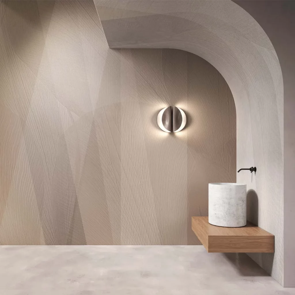 Overline von Tecnografica: sanft geschwungene Linien in Beige an einer Wand mit rundem Durchgang und Waschtisch.