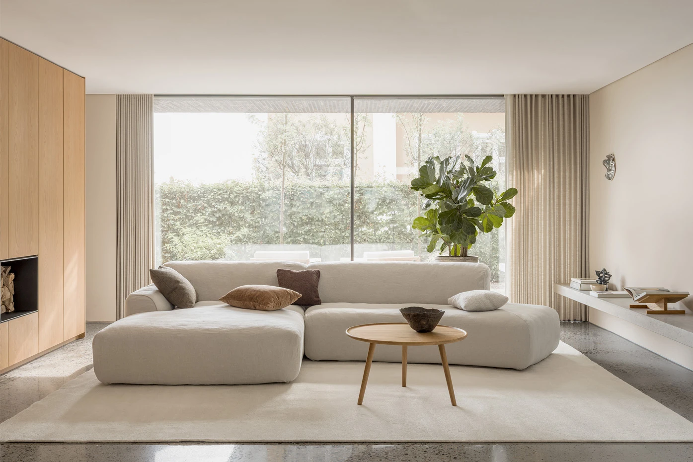 Helles modulares Sofa Emily von SITS mit breiten, gerundeten Sitzen in einem lichtdurchfluteten Wohnraum.